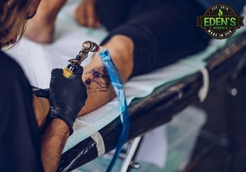 person getting their leg tattooed